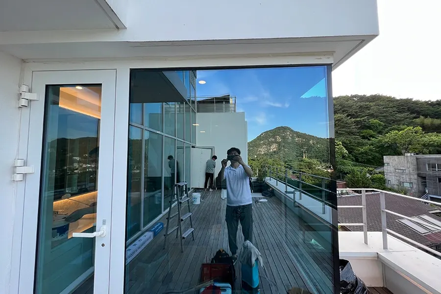 시공 현장에서 데크와 산 전망을 배경으로 작업 중인 코너창 모습