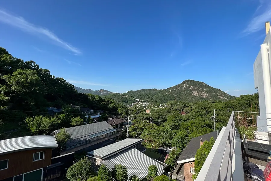 발코니에서 맨눈으로 바라본 산과 마을 풍경