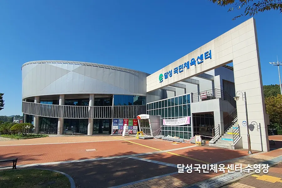 곡선형 파사드와 대형 통유리 로비를 갖춘 체육센터 건물 외관