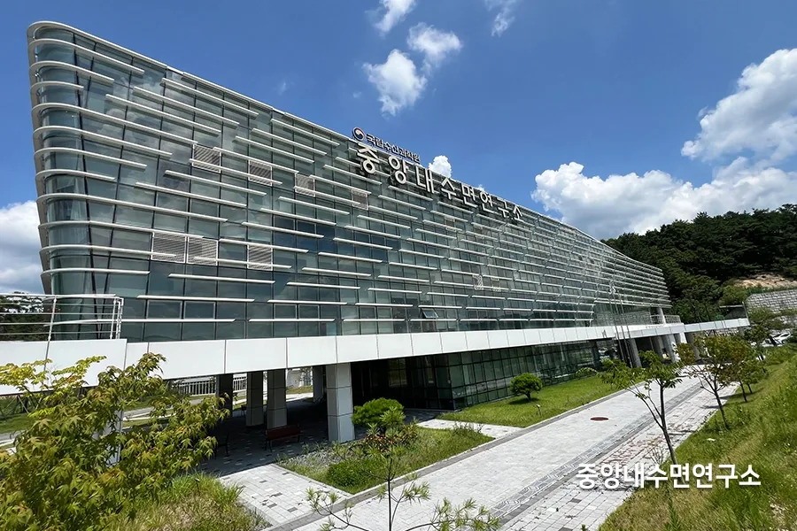 강변을 따라 유선형으로 이어진 연구소 건물 곡면 통유리 외벽 전경